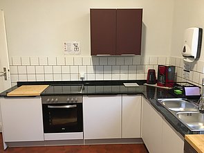 Komplett ausgestattete Küche mit Kaffeemaschine und Wasserkocher